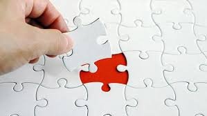 O mână care așază ultima piesă de puzzle la locul ei, simbolizând găsirea soluției și a strategiei pentru depășirea obstacolelor